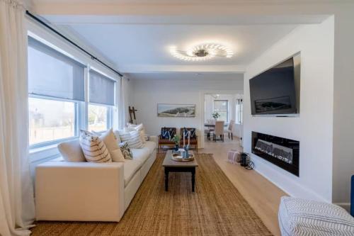 a living room with a white couch and a fireplace at Grand Bend 5BR Retreat Hot Tub, Fire Pit and BBQ in Grand Bend