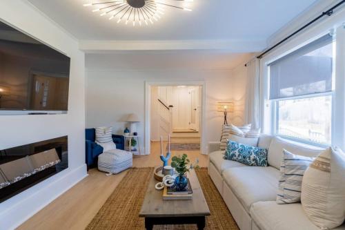 a living room with a white couch and a fireplace at Grand Bend 5BR Retreat Hot Tub, Fire Pit and BBQ in Grand Bend