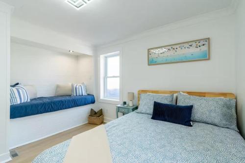 a bedroom with a blue bed and a window at Grand Bend 5BR Retreat Hot Tub, Fire Pit and BBQ in Grand Bend