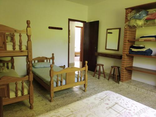 a bedroom with two bunk beds and a mirror at Chácara Tâmo na mió, Confortável casa de campo para famílias com Wifi, max 15 pessoas in Limeira