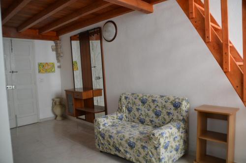 a room with a chair and a clock on the wall at agnesesguesthouse in Quartu SantʼElena