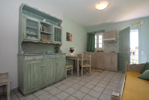 a kitchen with green cabinets and a table at Filoxenes Katoikies in Dhiakofti
