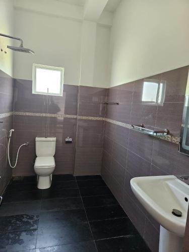 a bathroom with a toilet and a sink at Temuri Resort in Hambantota