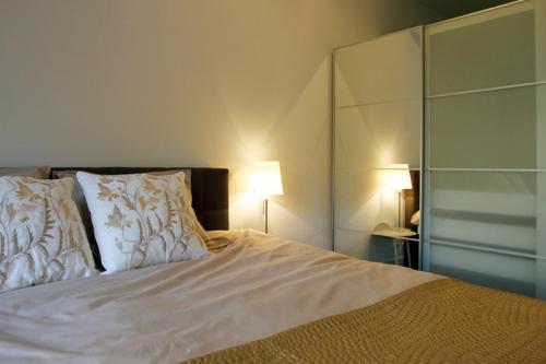 a bedroom with a white bed with two pillows at Parc Brussels Apartment in Brussels