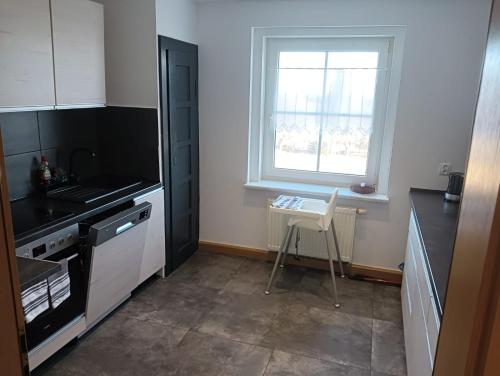 ヨハンジョルゲンシュタットにあるFerienwohnung Bergluftのキッチン(コンロ、窓、椅子付)