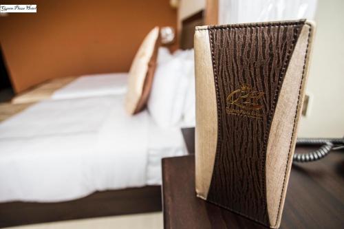 a book on a table next to a bed at Queen Plaza Hotel in Hebron