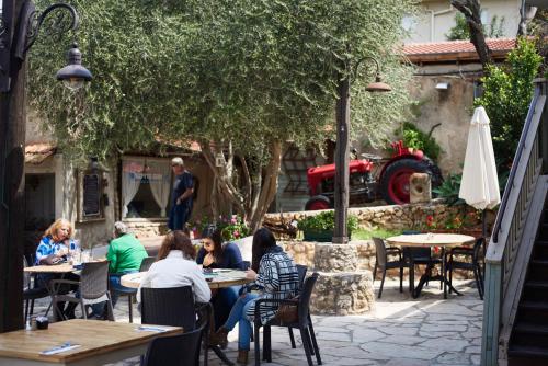 a group of people sitting at tables in a garden at Like Home Gedera in Gedera