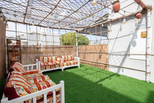 a patio with green grass and two couches at Frank Porter - Albizia Damac Hills 2 in Dubai
