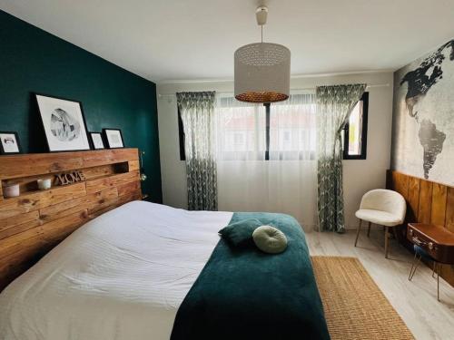 une chambre avec un grand lit et une chaise dans l'établissement Villa Poujeau - Piscine chauffée, à Le Pian-Médoc