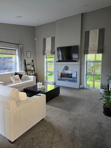 a living room with a white couch and a fireplace at Pegasus Golf course Awaiting in Woodend