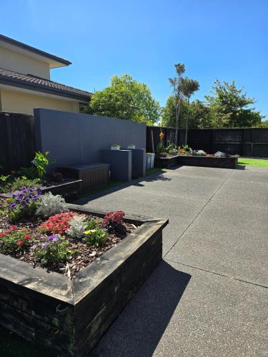 a garden with flowers and plants in a driveway at Pegasus Golf course Awaiting in Woodend