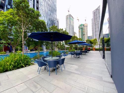a patio with tables and chairs and umbrellas at Star Residences KLCC in Kuala Lumpur