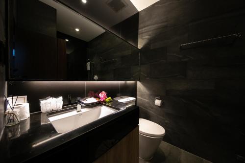 a bathroom with a sink and a toilet and a mirror at Hug Jang Loei Garden & Resort in Ban Na Dan