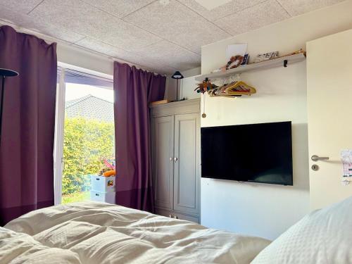 オーデンセにあるModern 3BR near Rosengård, City E20 & Congress Cのベッドと薄型テレビのある寝室