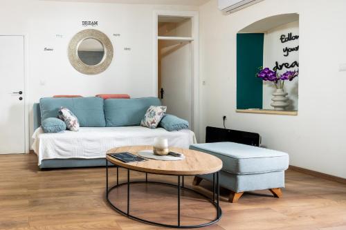 a living room with a blue couch and a table at Apartments Villa Sol in Ston