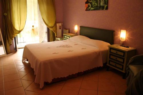 a bedroom with a white bed and a night stand at Casa Radiosa in Sora