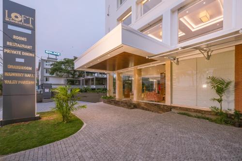 a building with a sign in front of it at Loft Business Hotel in Kakkanad