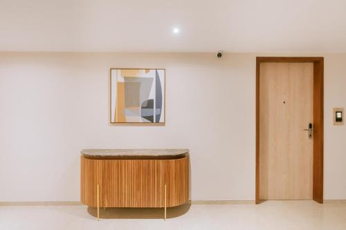 a stool in a room with a mirror and a door at Loft Business Hotel in Kakkanad