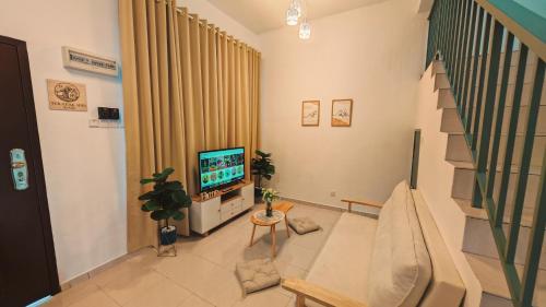 a living room with a television and a staircase at Teratak Seri Kelubi Homestay in Jasin