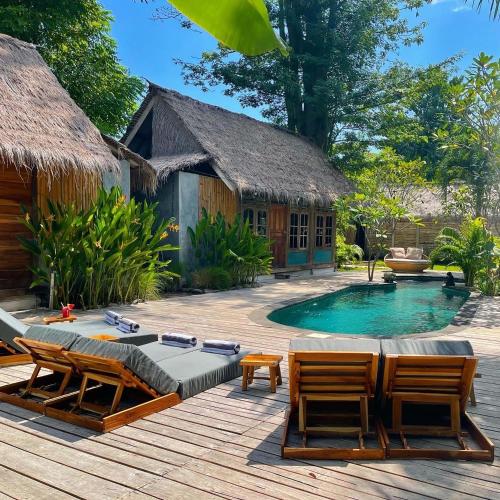 a resort with a pool and chairs and a house at Musa Bintang Villas and Bungalows Gili Air in Gili Air