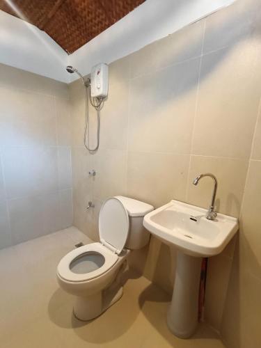 a bathroom with a toilet and a sink at Casa de Arte in Boracay