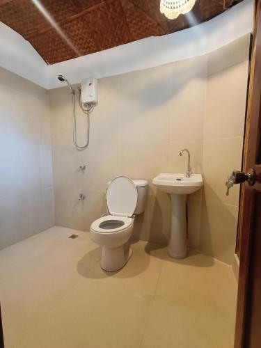 a bathroom with a toilet and a sink at Casa de Arte in Boracay