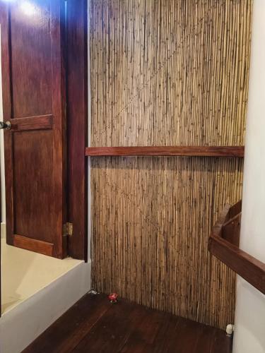 a bathroom with a wooden door and a wooden floor at Casa de Arte in Boracay