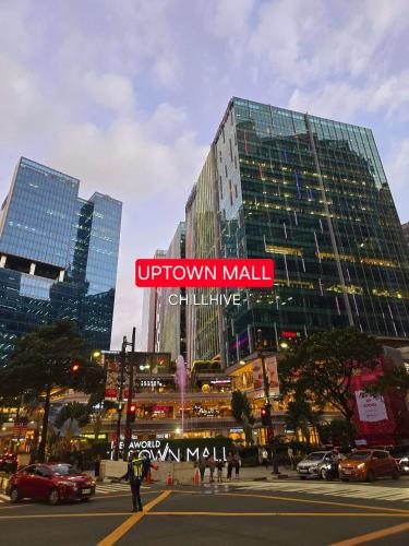 a tall building with a sign on it in a city at Prime BGC Condo: Uptown Mall & Hyatt #ournw21n in Manila