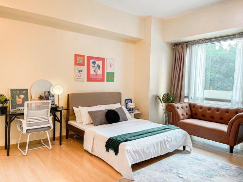Best Staycation in BGC Central #aatft13j في مانيلا: غرفة نوم بها سرير وأريكة