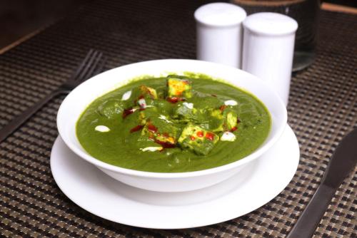 a bowl of green soup on a table at Paprika Stays Panjim Donapaula in Panaji