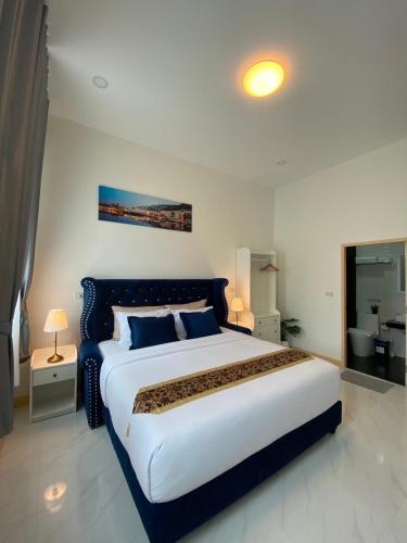 a large bedroom with a large bed with blue pillows at Le Trang Boutique Airport in Trang