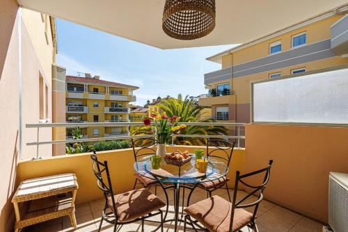 un balcon avec une table, des chaises et une fenêtre dans l'établissement Bel appartement Terrasse- Piscine- Tennis- Parking, à Vence