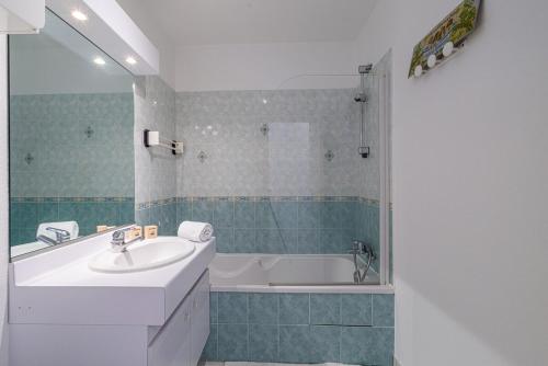une salle de bain avec un lavabo et une baignoire dans l'établissement Bel appartement Terrasse- Piscine- Tennis- Parking, à Vence