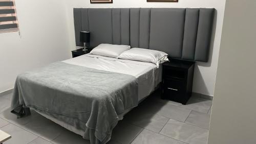 a bedroom with a large bed with white sheets and pillows at Departamento completo in Chihuahua