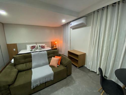 a living room with a couch and a bed at Manaus Hotéis Millenium - Flat 206 in Manaus