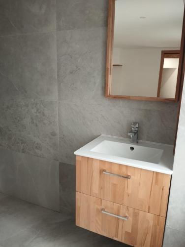 une salle de bain avec un lavabo blanc et un miroir dans l'établissement Cozy 2-bedroom village house, à Bompas