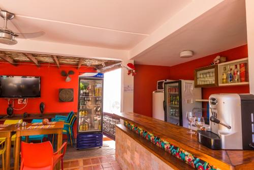 a restaurant with a bar with red walls at Pousada Bahia Brasil in Morro de São Paulo