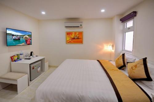 a bedroom with a large bed and a sink at Yellow Sea Hotel Nha Trang in Nha Trang