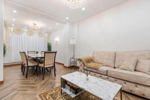 a living room with a couch and a table at Metro Majesty 5-Bedroom Gem in South Tottenham in London