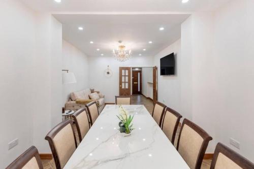 a dining room with a white table and chairs at Metro Majesty 5-Bedroom Gem in South Tottenham in London