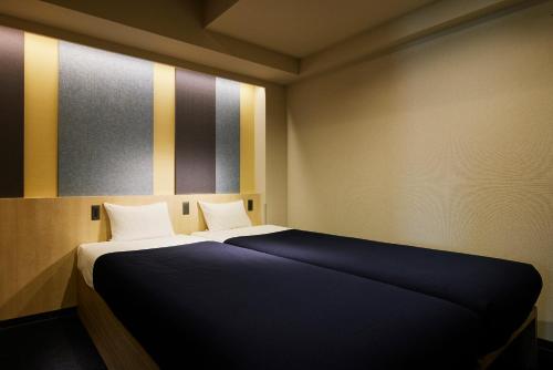 a bedroom with a bed with a blue blanket at Minn Asakusa Kappabashi in Tokyo