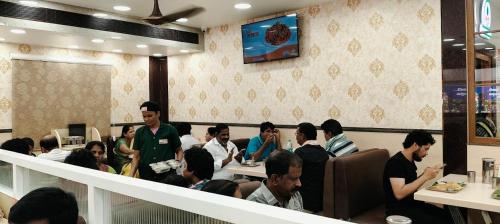 a group of people sitting in a restaurant at Padma Homes Stay- Luxury Service Apartment 1BHK & 2BHK & 3BHK in Tirupati