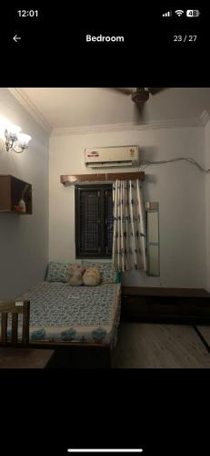 a small bedroom with a bed with a window at Snug Homestay in Kondapur