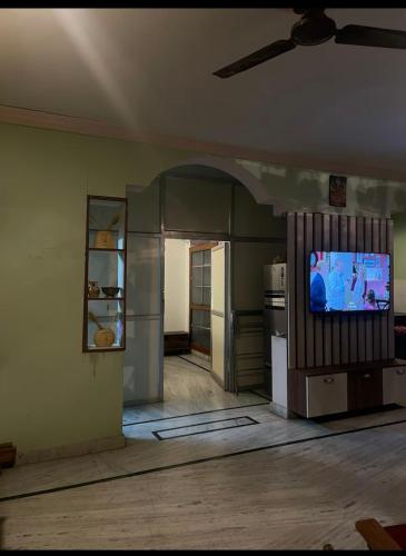 an empty room with a kitchen with a tv in it at Snug Homestay in Kondapur