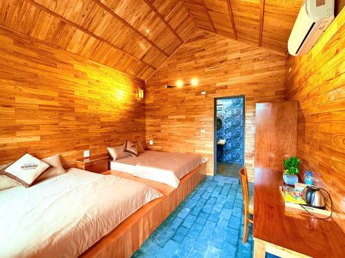 a bedroom with two beds in a wooden cabin at Ninh Binh Mountainside Bungalow in Ninh Binh