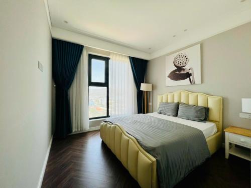 a bedroom with a large bed and a window at CĂN HỘ ALTARA Hương vị Biển in Quy Nhon