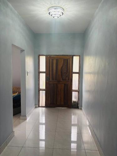 an empty room with a wooden door and windows at Mpande - The Roots Your Home Away from Home in Bulawayo