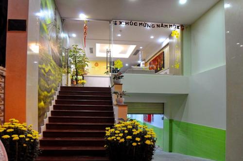 a staircase in a building with potted plants and flowers at Yellow Sea Hotel Nha Trang in Nha Trang