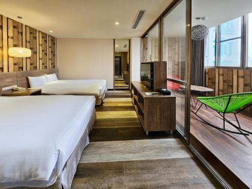 a hotel room with two beds and a television at CHECK inn Yilan LuoDong in Luodong