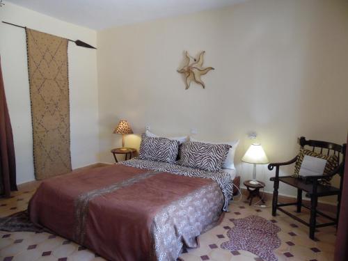 a bedroom with a bed and a chair at Villa Daba in Ghazoua
